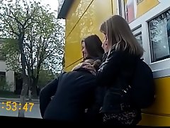 Drie meisjes bij de bushalte blik op de lul